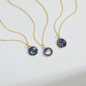Detailed set of three golden necklaces with sun, moon, and heart charms in blue enamel