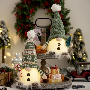 Plush Christmas gnomes with LED lights, knitted hats and candy canes on a wooden tray