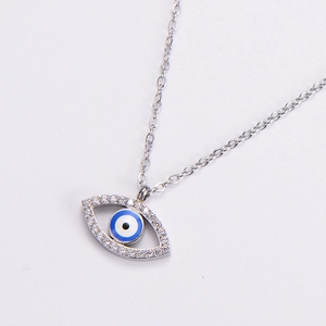 Macro shot of silver evil eye necklace pendant with blue enamel and pavé zircon stones