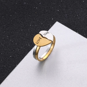 Detailed view of silver and gold stainless steel rings merging into a heart with LOVE engraving