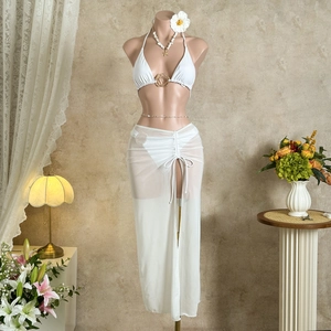Detail of white mesh beach sarong with side drawstring and high slit over bikini