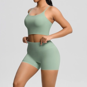 Detail of the high-waisted tight yoga shorts and thin strap sports bra in light green