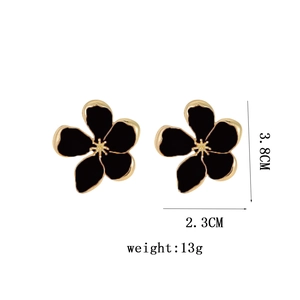 Exaggerated black enamel flower earrings with golden edges and minimalist metal design