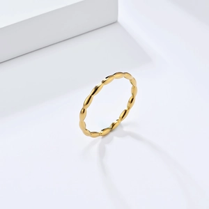 Close-up of polished gold titanium steel ring featuring a beaded drop geometry design