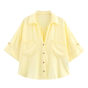 Détail d'une chemise en mélange de lin jaune clair avec doubles poches et boutons en bois