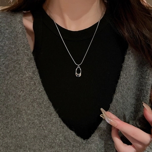 Polished silver hollow O-ring pendant necklace on model with minimalist black top