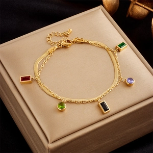 Double-layered gold bracelet with colorful gem pendants and snake chain design
