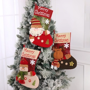 Tre calze natalizie in maglia con Babbo Natale, renna e pupazzo di neve su albero bianco