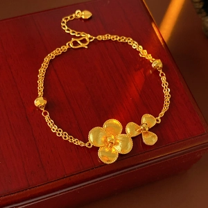Detail of vintage gold-plated flower bracelet with S-hook clasp and heart charm