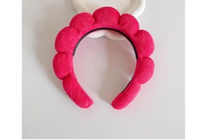 Close-up of a thick red braided sponge headband with soft texture on white background