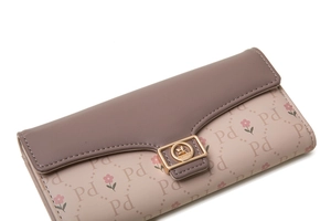 Close-up of pink PU leather wallet with floral alphabet print and gold buckle