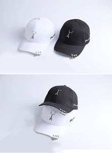 Detail of Paris embroidery and metal ring accents on black and white baseball caps
