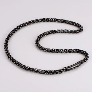 Close-up of black braided stainless steel chain necklace with cylinder clasp detail