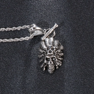 Macro shot of silver titanium steel Indian chief skull pendant with feather details