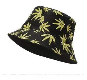 Close-up of black bucket hat featuring yellow maple leaf patterns and street style