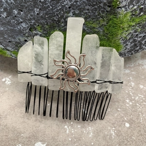 Macro detail of natural quartz crystals and sun emblem hand-wrapped on a metal hair comb