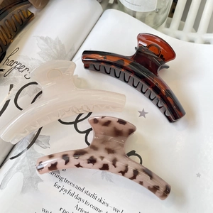 Three-piece hair claw set in amber, cream, and pink leopard print on magazine