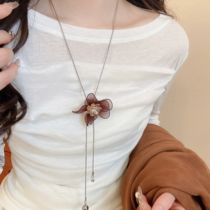 Detailed view of dark brown mesh flower pendant necklace with shimmering diamond accents