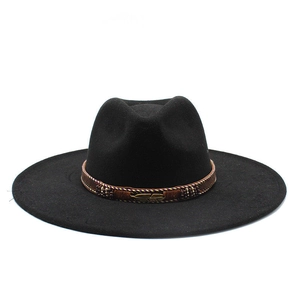 Detail of black felt jazz hat with brown braided band and golden feather metal buckle