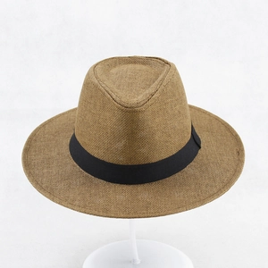 Close-up of woven sun hat texture with black decorative band on white stand