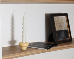 Detailed macro view of a white spiral candle on a yellow ceramic base minimalist home decor