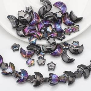 Macro shot of iridescent purple and black moon and star charms for DIY jewelry making