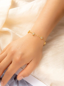 Detail of vintage emerald zircon bracelet on wrist with gold chain and beaded edge