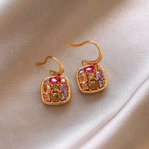 Macro detail of 18k gold plated earrings featuring multi-color square zircon stones