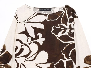 Detail of floral printed top showing fabric texture, buttons and collar label detail