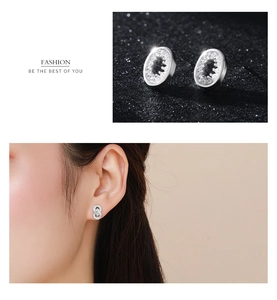 Détail macro de boucles d'oreilles ovales argentées avec pavé de zircone étincelant