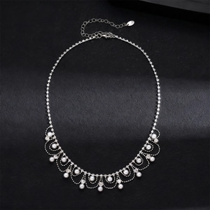 Détail du collier argenté orné de perles d'imitation élégantes et de strass scintillants