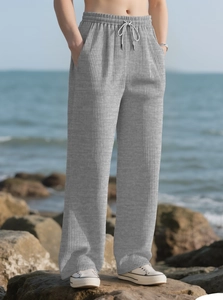Detailed view of light grey wide leg trousers with textured knit vertical stripes and drawstring