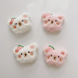 Detailed view of white and pink teddy plush bear charms with strawberry embroidery