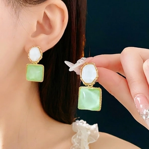 Elegant gold earrings with sparkling white circles and light green square stones