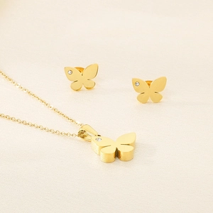 Detail of gold butterfly jewelry set with shimmering crystals on earrings and necklace