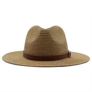 Close-up of the straw sun hat texture with brown leather band and silver buckle