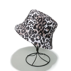 Dettaglio del cappello a secchiello leopardato su supporto in metallo nero