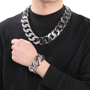 Polished silver stainless steel Cuban link necklace and bracelet set on male model