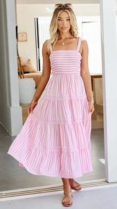 Détail d'une robe d'été à rayures roses avec jupe à volants et corsage froncé pour les vacances