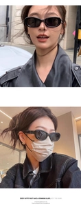 Detail of black cat-eye sunglasses with white four-stitch signature on the side temples