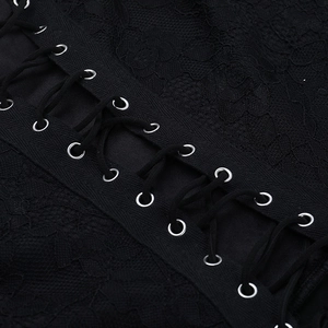 Détail de laçage croisé avec œillets métalliques sur une combinaison en dentelle noire
