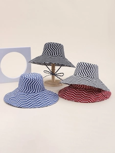 Detail of multi-color polka dot sun hats with wide brims and decorative wavy patterns