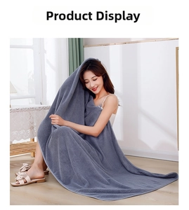 Dark grey coral fleece waffle bath towel draped on a woman in a bright home setting