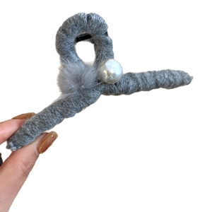 Elegant grey knitted claw clip featuring a large center pearl on a white background
