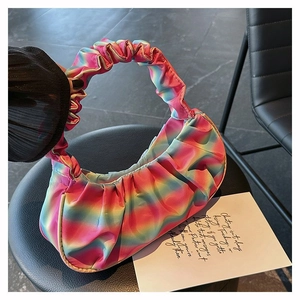 Detail of a rainbow gradient pleated dumpling bag with soft satin texture and top handle