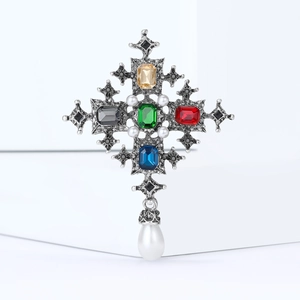 Detail of baroque cross brooch with colorful gemstones and teardrop pearl pendant