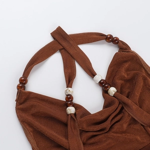 Detail of deep brown ribbed knit dress with marbled white and brown bead strap accents