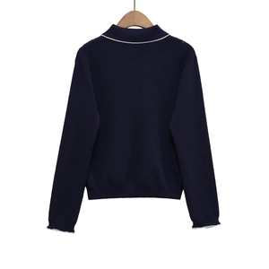 Navy blue knitted cardigan with white wavy embroidery on collar and hem, rear view