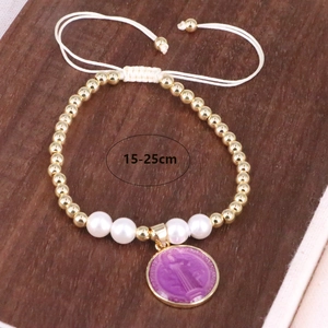Detail of adjustable white braided bracelet with gold beads, pearls and purple pendant