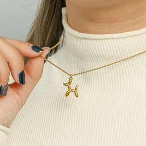 Golden balloon dog pendant necklace on titanium steel chain worn by a model